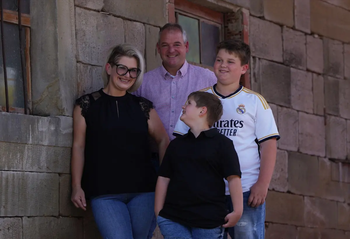 Die Familie Dieroff steht vor der Sandsteinmauer des Hofgebäudes.